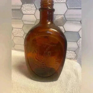 Vintage Log Cabin Syrup bottle in amber colored glass with Native American